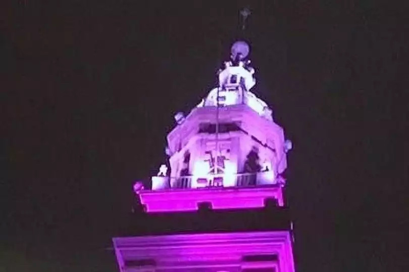 Never Give Up: la torre civica si colora di lilla